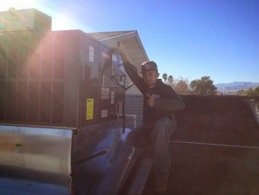 HVAC technician performing Boiler Repair on a rooftop unit in St. Charles